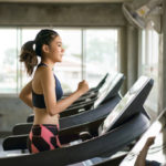 A young woman Running on a treadmill for cardiovascular exercise.