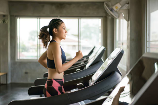 A young woman Running on a treadmill for cardiovascular exercise.